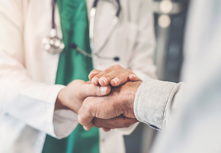Surgeon holding patient's hand